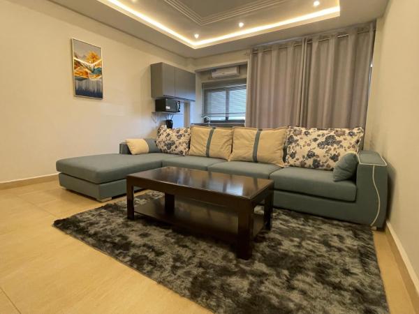 Living room with gray sectional sofa, floral and plain cushions, dark wood coffee table, and gray rug