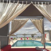 a canopy over a swimming pool with a red couch next to it at Hotel La Residence Hammamet