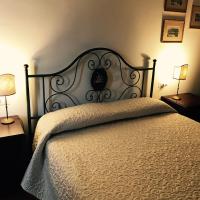 a bedroom with a bed with a white comforter and two lamps at B&B La Dimora del Capitano, Fabriano