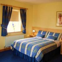 a bedroom with a bed and a window with blue curtains at Feerick's Hotel, Rathowen