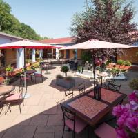 an outdoor patio with tables and chairs and umbrellas at Logis Hôtel Atrium Epinal, Épinal