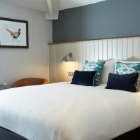 a bedroom with a large white bed with blue pillows at Hartwood Hall by Greene King Inns, Chorley
