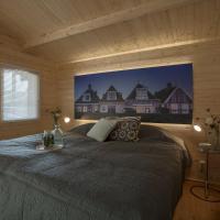a bedroom with a bed in a wooden cabin at Lodgehotel de Lelie, Makkum