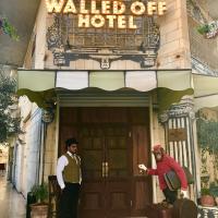 two men standing in front of a hotel at The Walled Off Hotel, Bethlehem