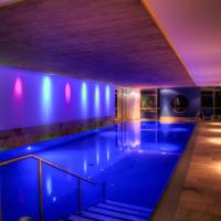 a swimming pool in a building with blue lights at Hotel Grossfeld, Bad Bentheim