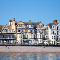 a group of buildings on a beach next to the water at The Kingswood Hotel, Sidmouth