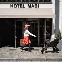 a woman walking a dog on a leash at Mabi City Centre Hotel, Maastricht