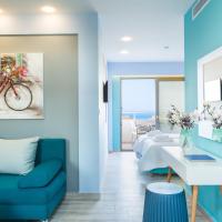 a living room with a blue couch and a room with a bed at Menta City Boutique Hotel, Rethymno
