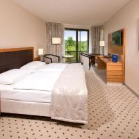 a hotel room with a large bed and a desk at Maritim Hotel Bad Homburg, Bad Homburg vor der Höhe