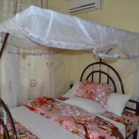 a bedroom with a bed with a canopy at Barcelona Lodge, Bagamoyo
