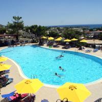 a pool with people swimming in it with yellow umbrellas at Marianthi Studios & Apartments, Pefki