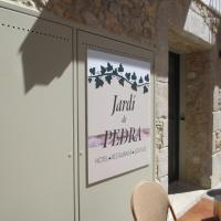 a sign on a door with a table and chairs at Jardi de Pedra, L'Escala