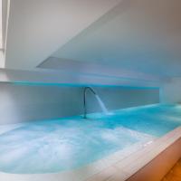 a hot tub with blue water in a room at Hôtel Montaigne & Spa, Cannes