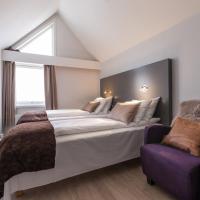 a bedroom with a large bed and a purple chair at Enter Viking Hotel, Tromsø