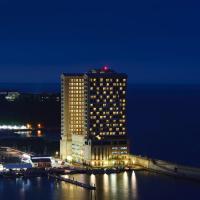 a tall building with lights on it at night at Ramada by Wyndham Gangwon Sokcho