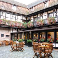 a courtyard of a building with chairs and flowers at Le Gouverneur Hotel, Obernai