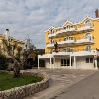 a yellow building with balconies on the side of it at Hotel Crnogorska Kuća, Podgorica