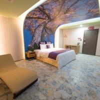 a hotel room with a bed and a painting on the wall at Ting-Shuai Motel, Jinshan