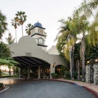 a building with a clock tower and palm trees at Vanllee Hotel, Covina