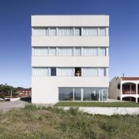 a building with a woman looking out of a window at Vista Hotel, Villa Gesell