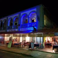 a restaurant with a blue sign on the side of a building at Hotel Valiha, Antsiranana