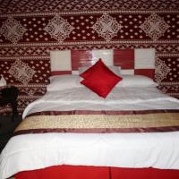 a bedroom with a large bed with a red pillow at Wadi Rum Quiet Village Camp