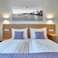a bedroom with a bed with two blue pillows at McDreams Hotel Düsseldorf-City