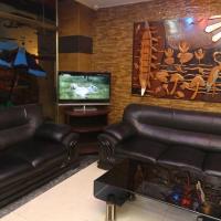 a living room with two leather chairs and a television at Grand Beach Resort, Cox's Bazar