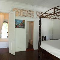 a bedroom with a bed and an open doorway at Hotel Florita Residential Hotel, Jacmel