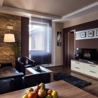 a living room with a couch and a television at Hotel Garzon Plaza, Győr