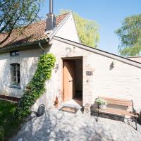 a small white building with a dog sitting in front of it at B&B De Hanewijkhoeve, Werchter