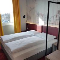 a bedroom with two beds with a large window at Campanile Leipzig Halle Airport