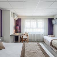 a hotel room with two beds and a desk at Logis Hotel Le Sablier du Temps, Argentat