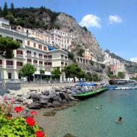 a group of people swimming in a river with buildings at Hotel La Bussola, Amalfi