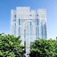 a tall glass building with trees in front of it at The Carlton Taichung