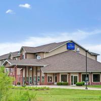 a large brick building with a blue sign on it at Baymont by Wyndham Indianapolis