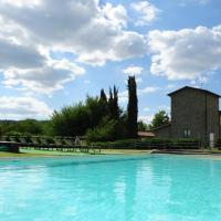 a large swimming pool with chairs and a building at Agriturismo Il Sasso, Anghiari