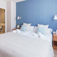 a bedroom with a large white bed with a blue wall at Mumm by Pillow, Vilanova i la Geltrú