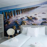 a bedroom with a large painting of a pier at City2Beach Hotel, Vlissingen