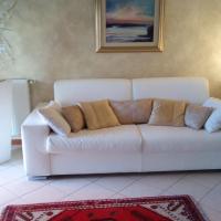 a white couch in a living room with a red rug at Atelier, Portogruaro
