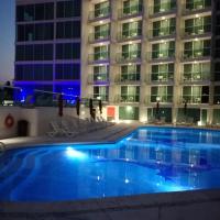 a swimming pool in front of a building at night at We Hotel Acapulco