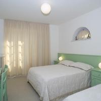 a bedroom with two beds and a desk and a television at LIù B&B, Torre del Lago Puccini