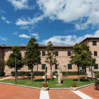 a courtyard of a large brick building with trees at Hotel Le Muse, Fabriano