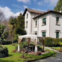 a white house with an umbrella in front of it at Villa del Cigno, Lecco