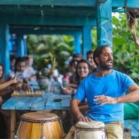a group of people sitting around a table with drums at Lobo Hostel Bar, Cabo Polonio