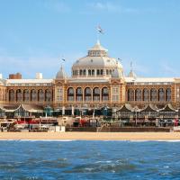 a large building on the beach in front of the water at Grand Hotel Amrâth Kurhaus The Hague Scheveningen