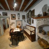 a living room with a table and a stone fireplace at Old Traditional House, Mandrakion