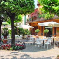 a patio with tables and chairs and umbrellas at Hotel Don Abbondio, Lecco