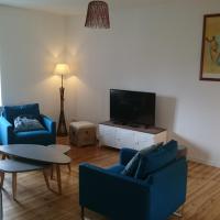 a living room with two blue chairs and a tv at Maison de village/Appartement de charme avec extérieur, Loudenvielle