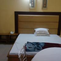 a bedroom with a large bed with a wooden headboard at Royal Park Residential Hotel, Chittagong